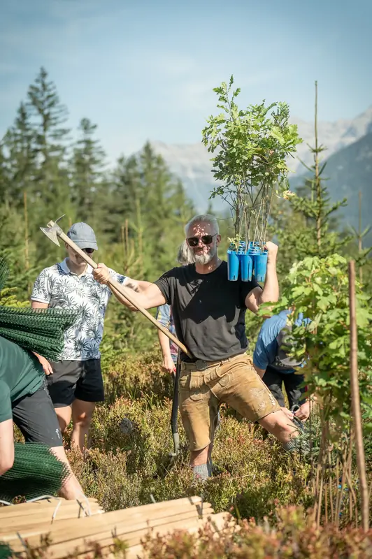 Pflanzteam bei der Arbeit mit blauen Setzlingskisten