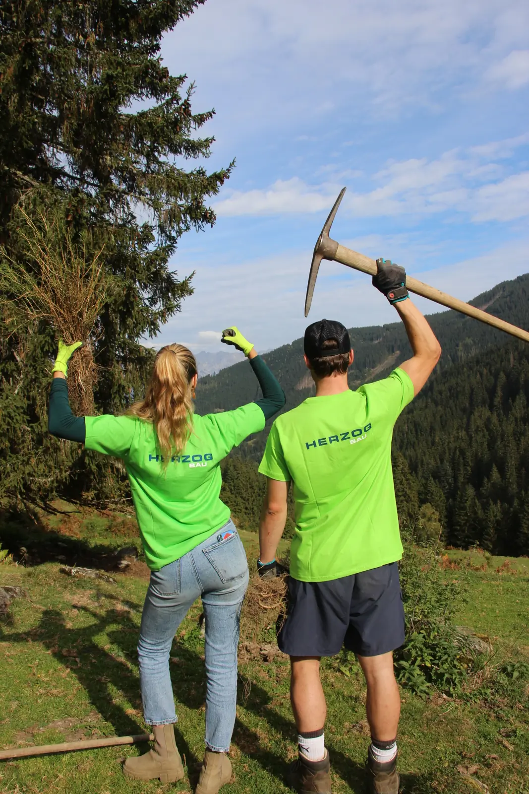 Zwei Personen in Bäume-für-Morgen-Shirts heben ihre Werkzeuge